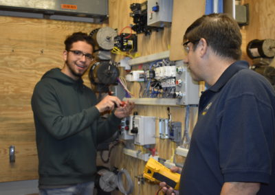 Electrical student showing teacher work