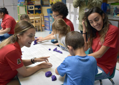 Childcare students smiling with child