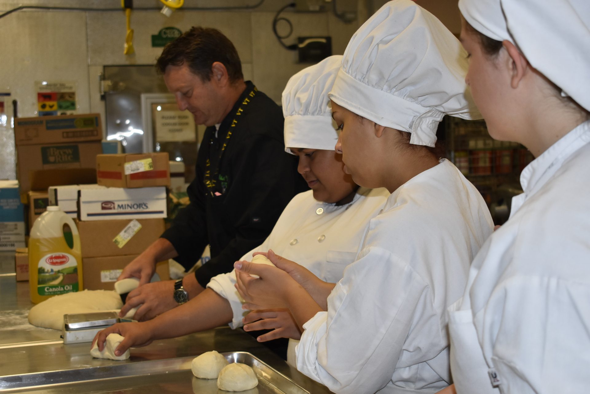 Culinary students kneading dough