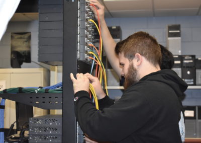 Informational technology students plugging in wires