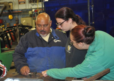 Welding students talking to their teacher