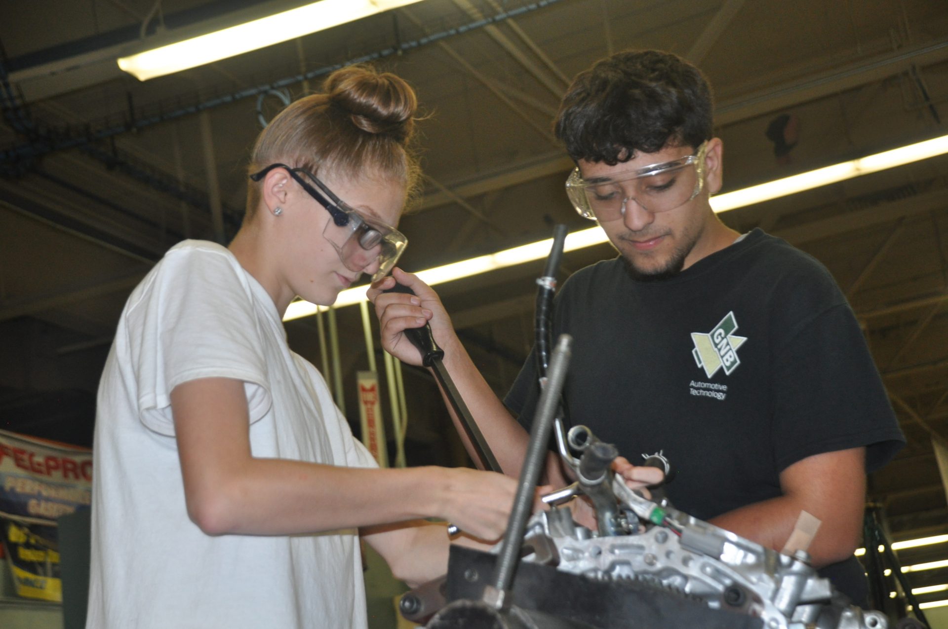 Automotive students working on a car engine