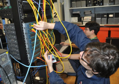 Informational technology student plugging wires in