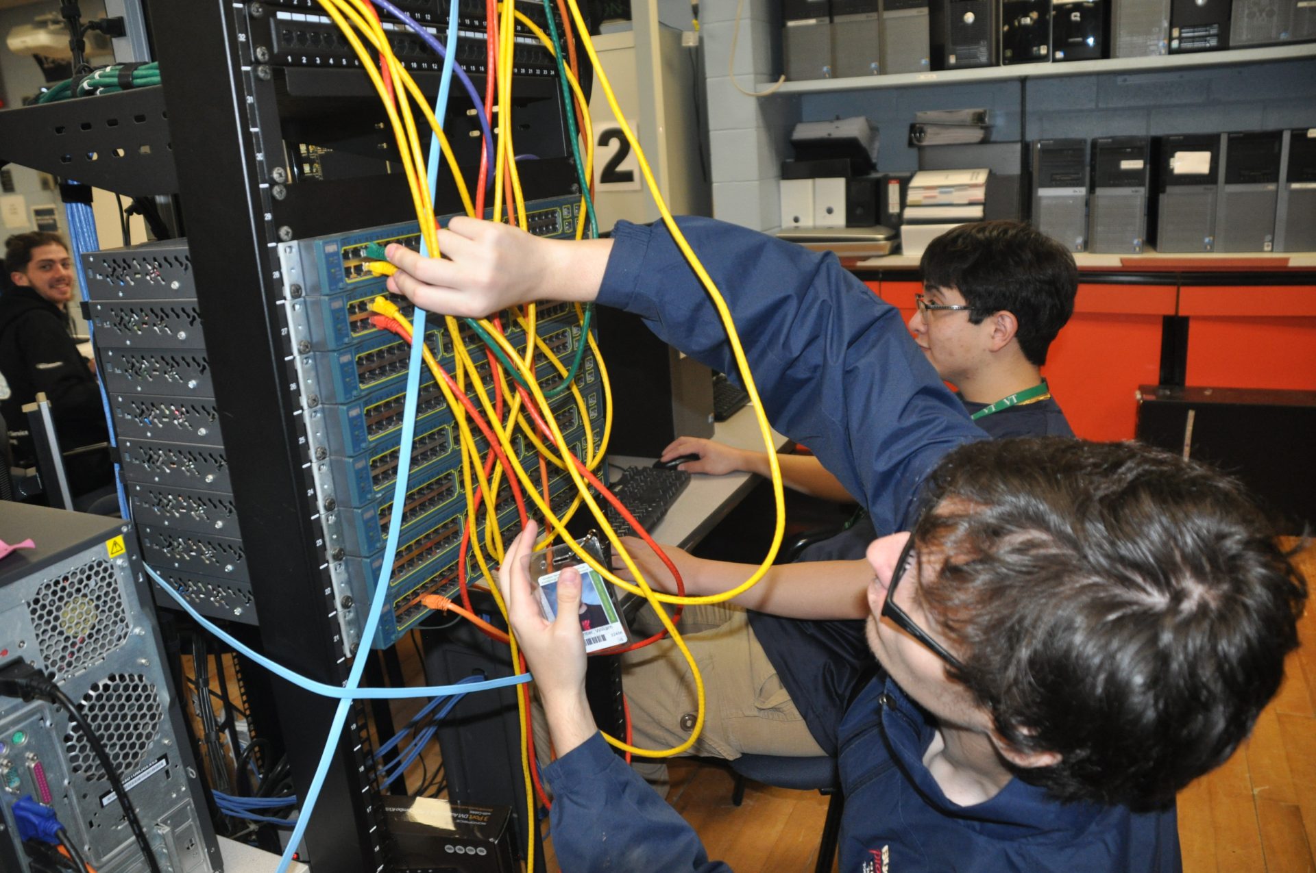 Informational technology student plugging wires in