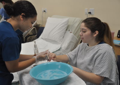 Nursing Assistant students cleaning patients hands and nails
