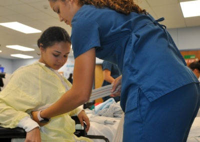 Nursing Assistant students hoisting a student from a wheelchair
