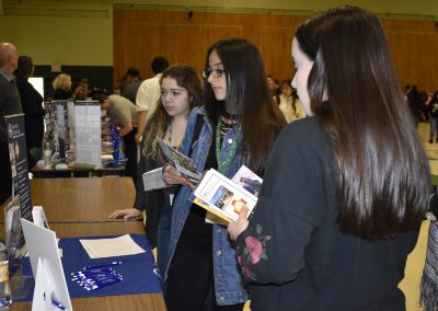 Students Looking At A College's Mini-Poster