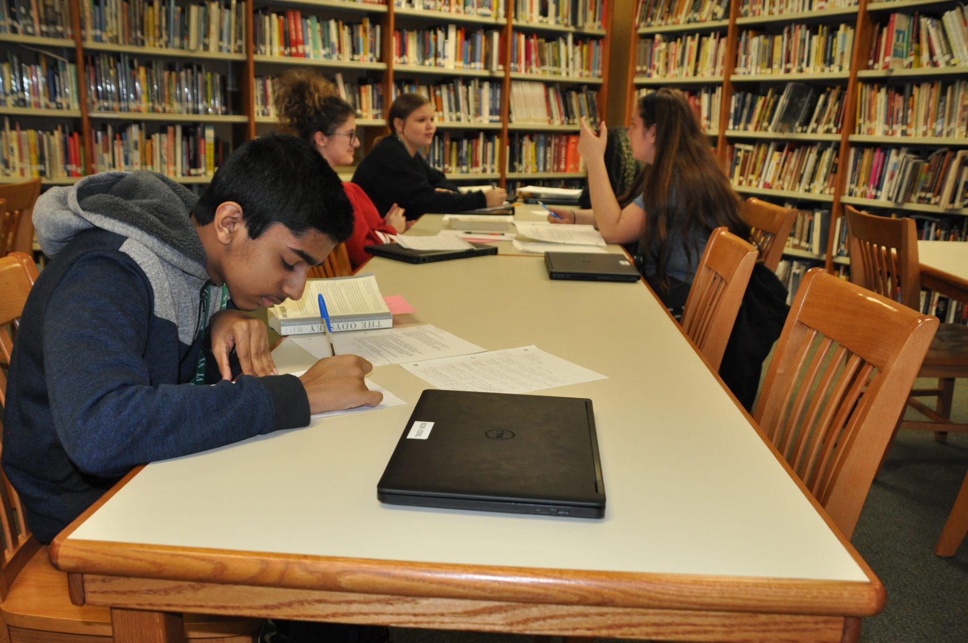 Students writing and conversing in the library