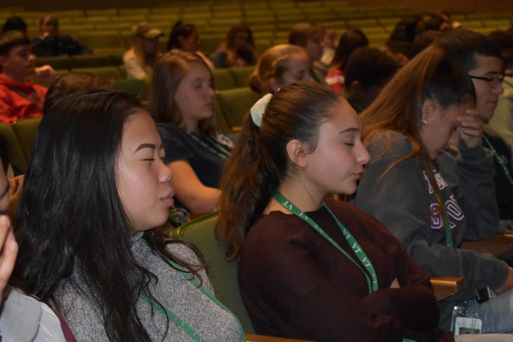students with eyes closed in the audience