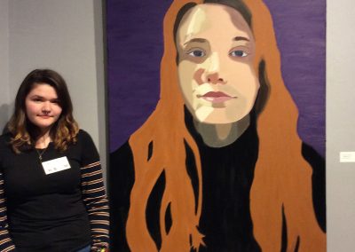 Teen Artist Internship student standing near their artwork