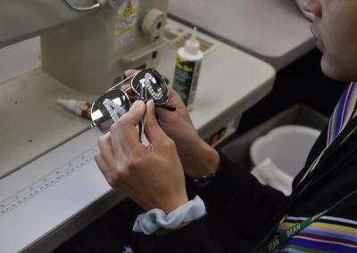 Fashion design student working on pulling stones on sunglasses