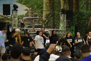 Students standing on stage pointing from hypnosis