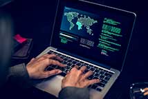 Stock photo of a man hacking on a computer