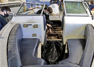 marine exploratory student scrapping boat properly