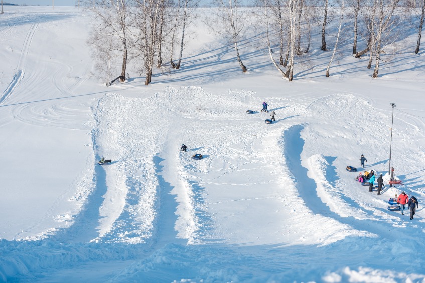 a lot of people ride a tubenge. skiing from the mountain in winter. winter fun