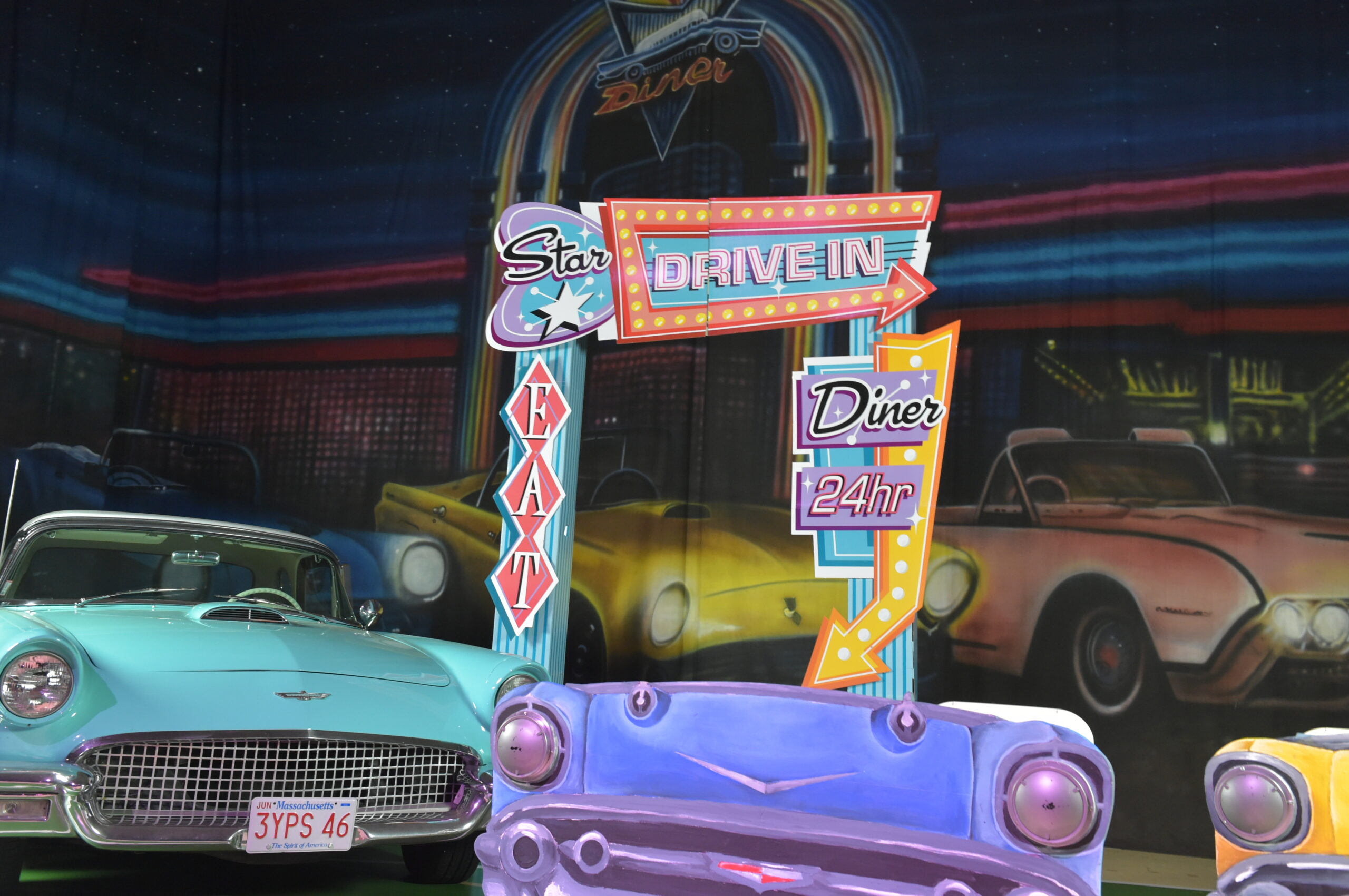 Area with a different variety of old cars with a sign saying "Star Drive in"