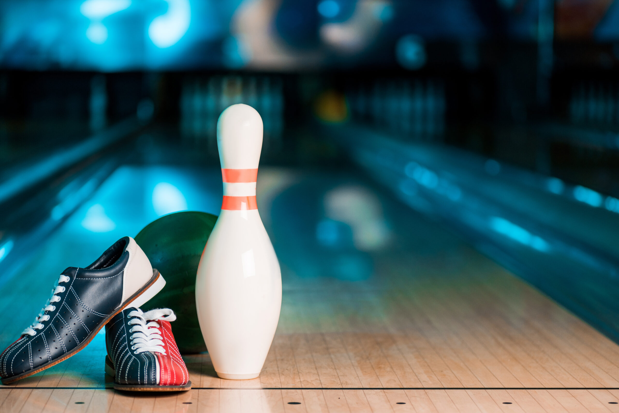 Selective focus of bowling shoes, ball and skittle on bowling alley