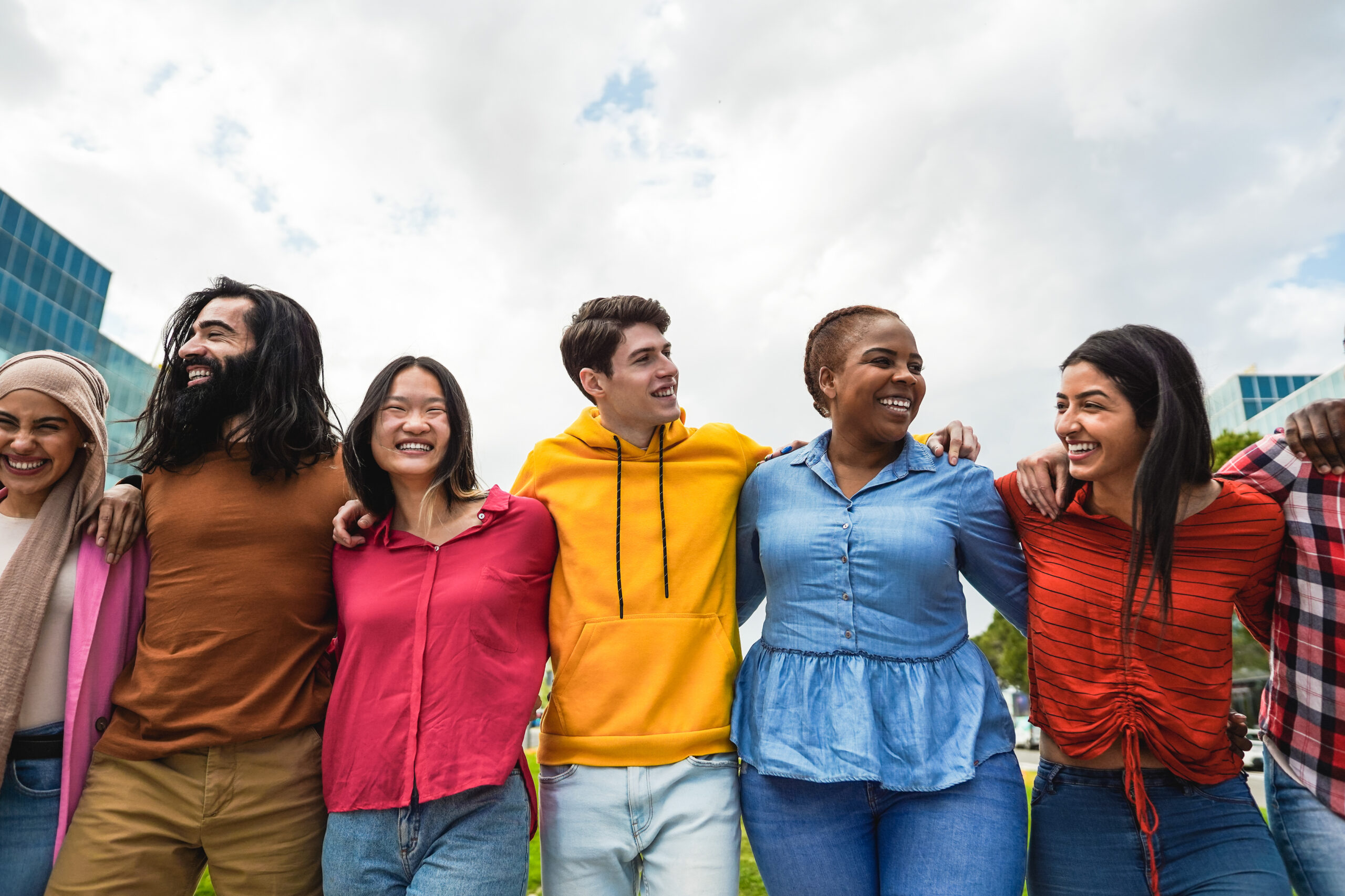 Young diverse people having fun walking together outdoor - Focus on center man face